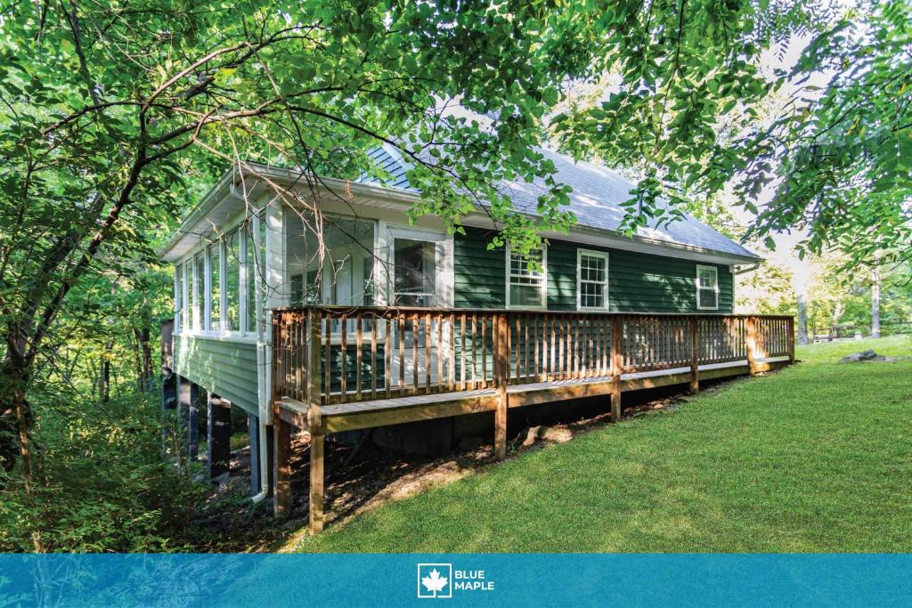 a green house sitting in the middle of a yard at Shenandoah mountain cottage w hot tub & fire pit in Front Royal