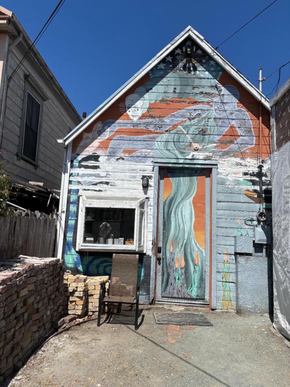 a building with a painting on the side of it at Cottage Bed 1 at FacesOasis in Oakland