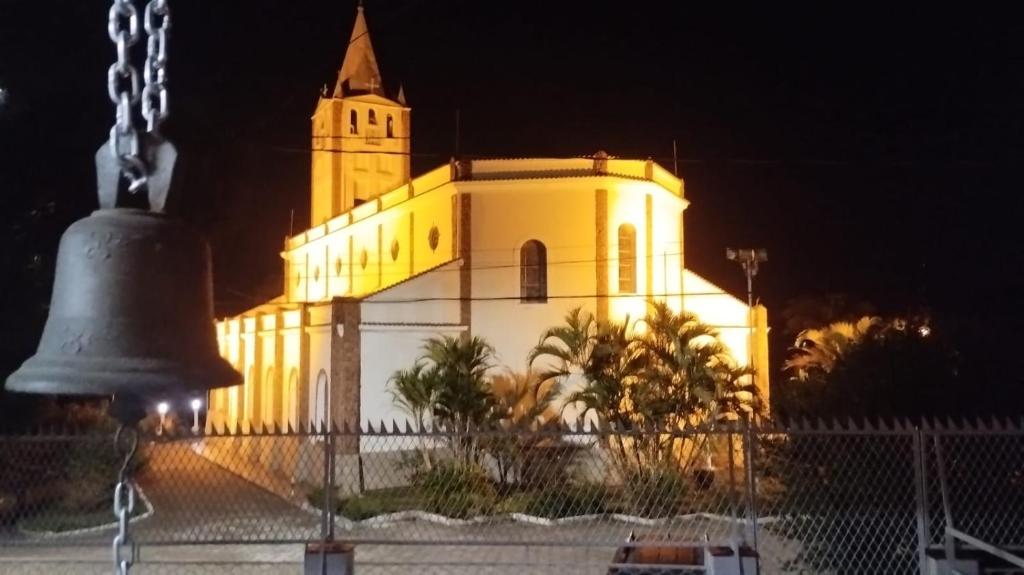 a large building with a bell in front of it at Recanto da Matriz - Águas da Prata in Águas da Prata