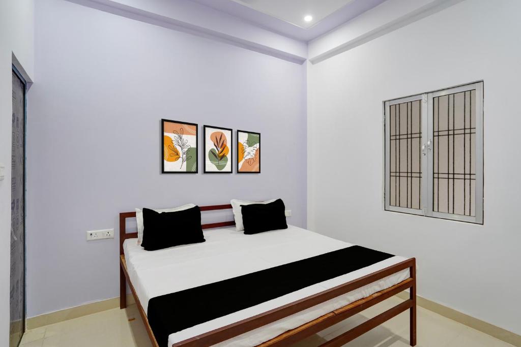 a white bedroom with a bed in a room at Hotel O AVS Inn in Bheta