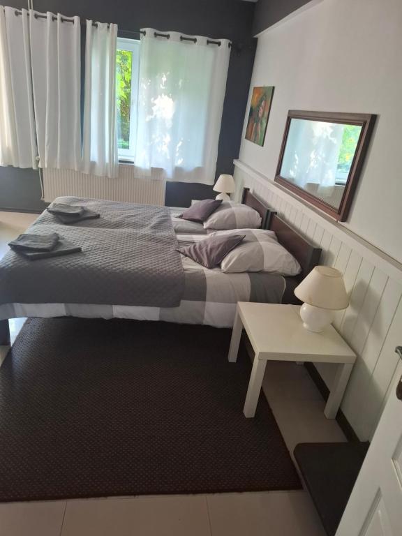 a bedroom with two beds and a small table at dom & weranda in Szczęsne