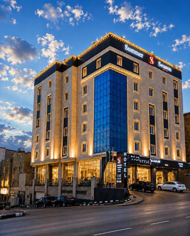 a large building with cars parked in front of it at فندق فصل الصيف امان - المنسك in Abha