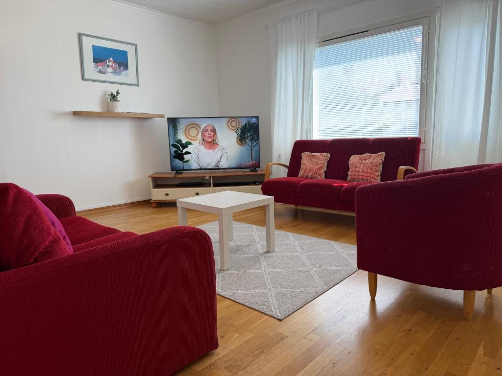 a living room with two red couches and a white table at Malmi Home in Vaasa