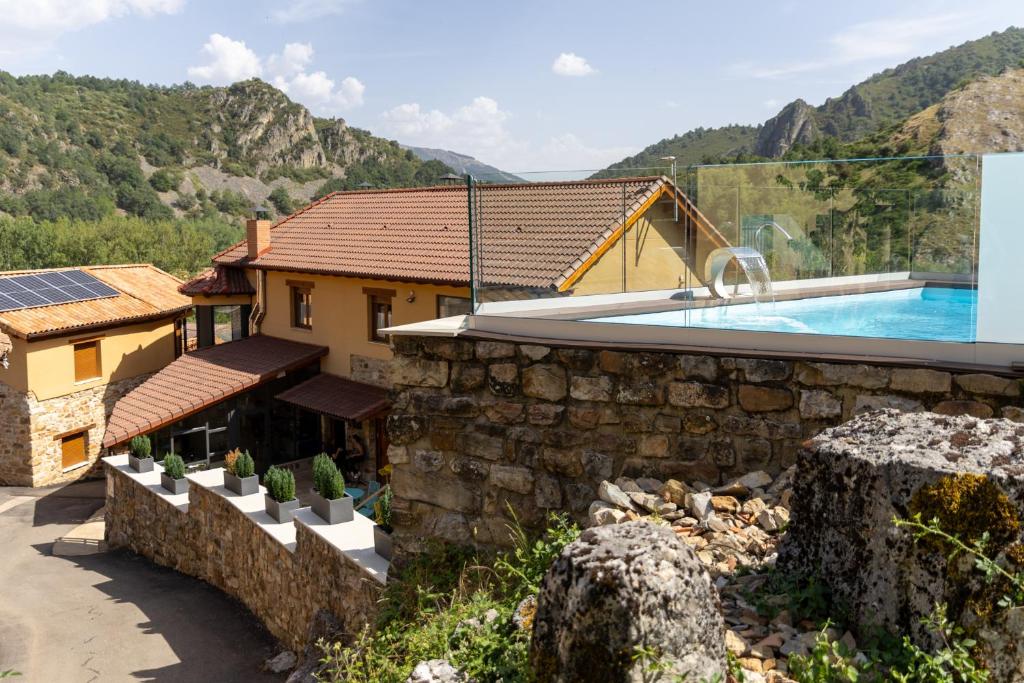 a house with a swimming pool and a mountain at El Hotel & SPA de Verdiago in Verdiago