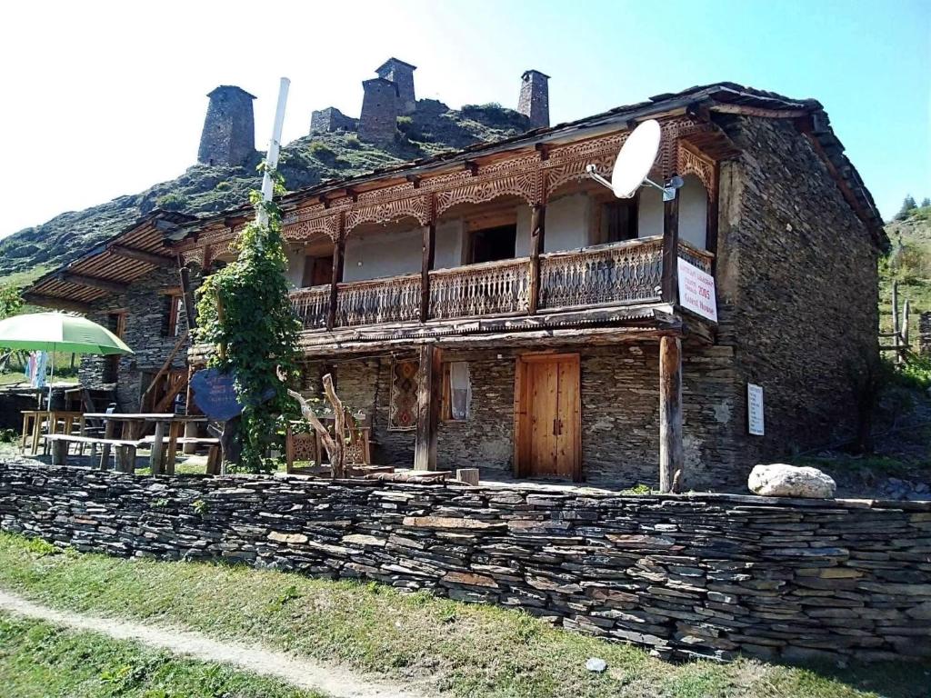 an old stone house with a balcony on a stone wall at Hotel Omalo2005 in Omalo