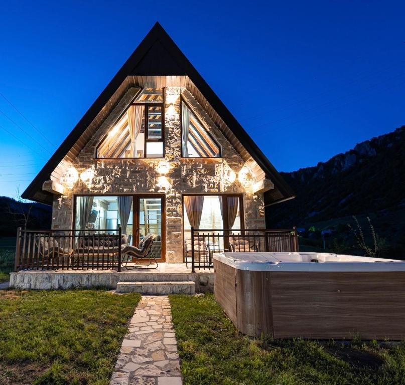 a house with a hot tub in front of it at VILA K3 Komarnica in Šavnik