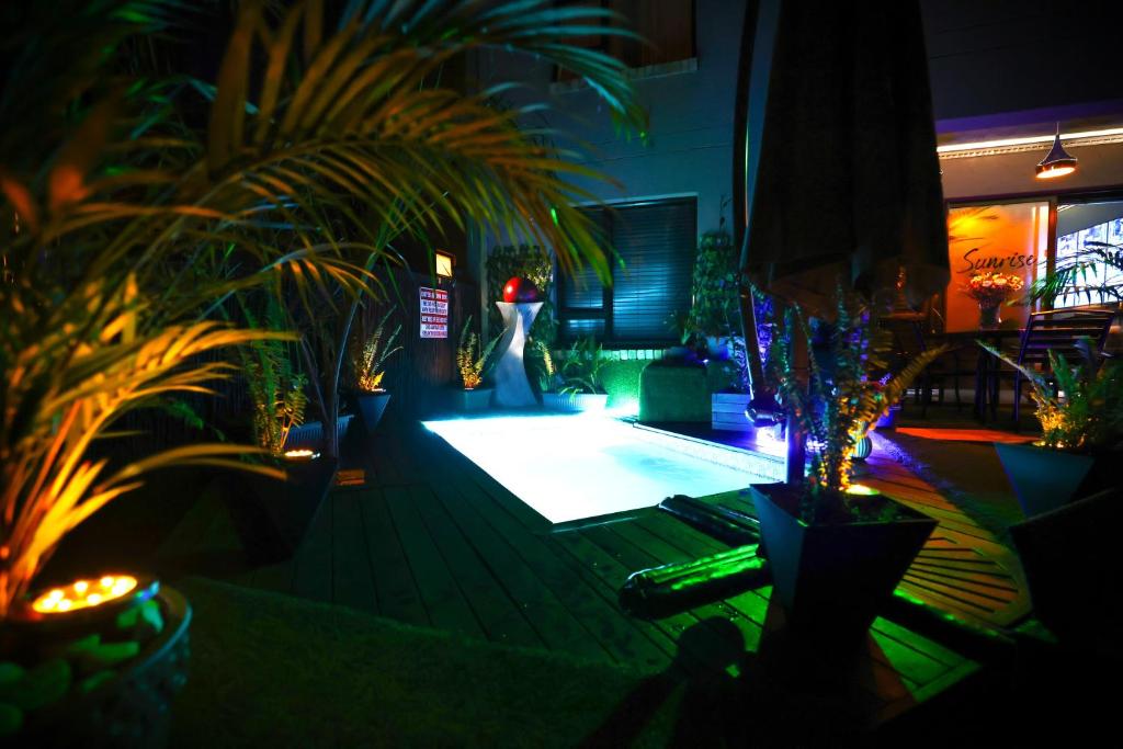 a room with a pool with plants and lights at Heated Pool Luxury Retreat - 7 Min from OR Tambo in Benoni