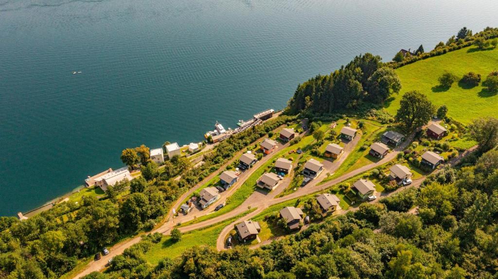 an aerial view of a house on a hill next to the water at Kantor Village am Millstätter See - Boutique-Chalets und Lodges in Millstatt