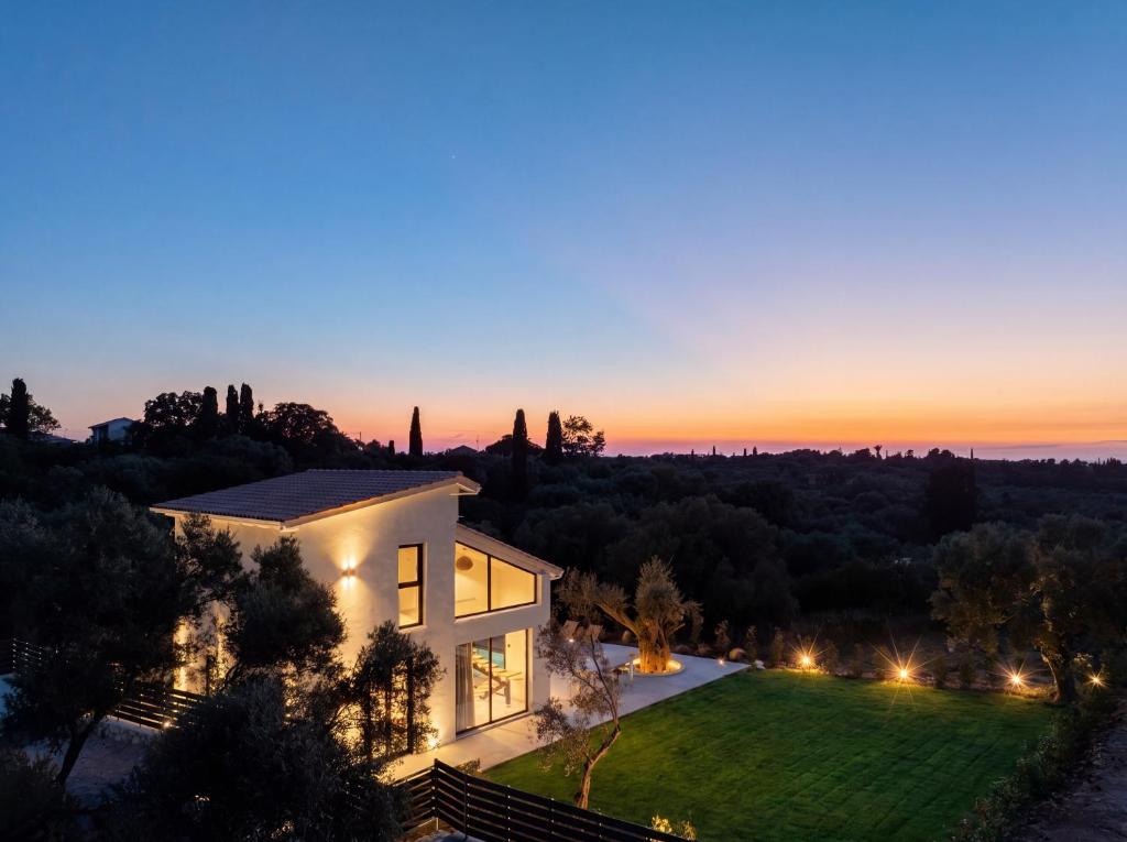 a house with a sunset in the background at Avelia Villa Tsoukalades in Tsoukalades