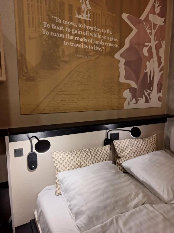 a bedroom with two beds and a poster on the wall at Fyrtojet in Odense