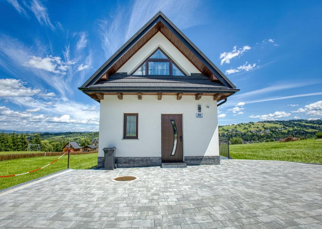 a small white house with a roof at Mery House Agroturystyka in Biały Dunajec