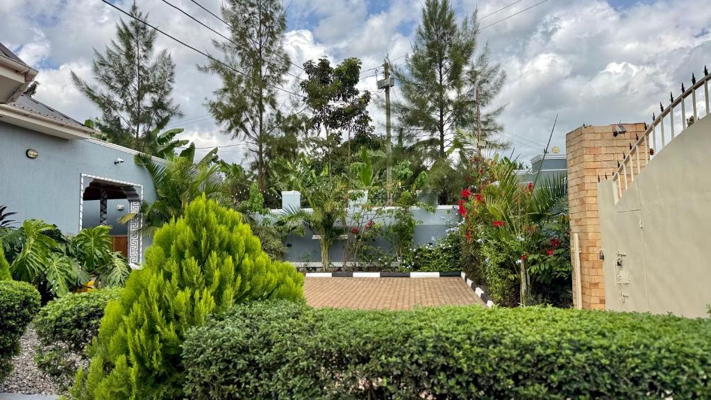 a garden with trees and bushes and a house at Murchison Close Motel in Masindi