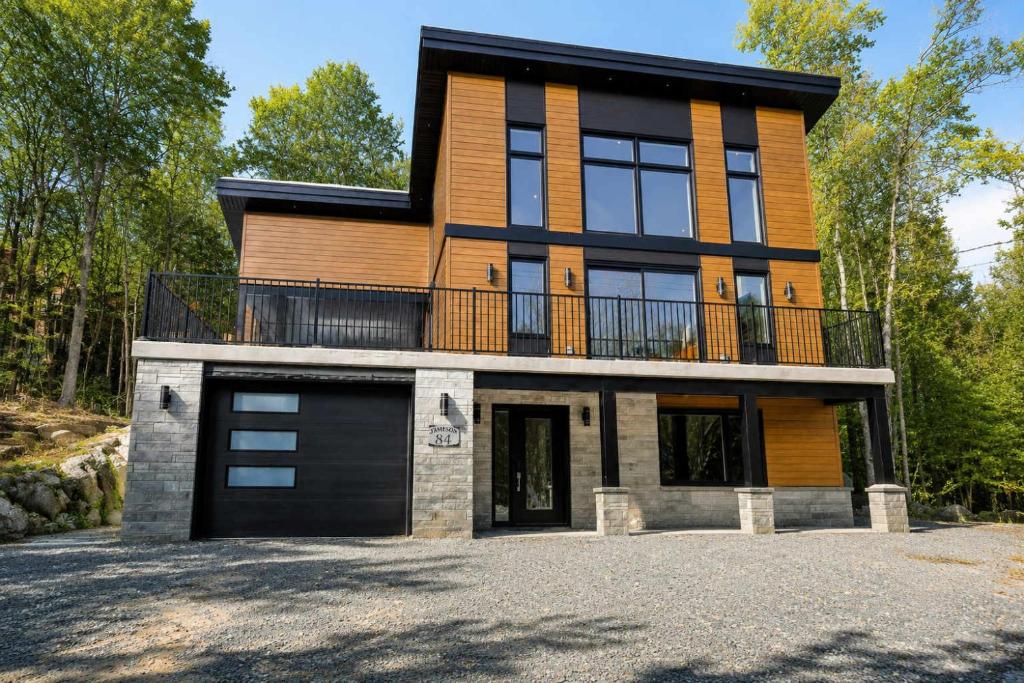 a large house with a garage in front of it at Spa Mountains & Ultimate Comfort - Le Jameson in Saint-Philémon