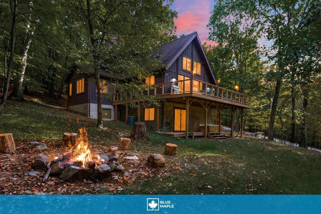 a log cabin with a fire in front of it at Cabin w hot tub & fire pit near Cacapon in Berkeley Springs
