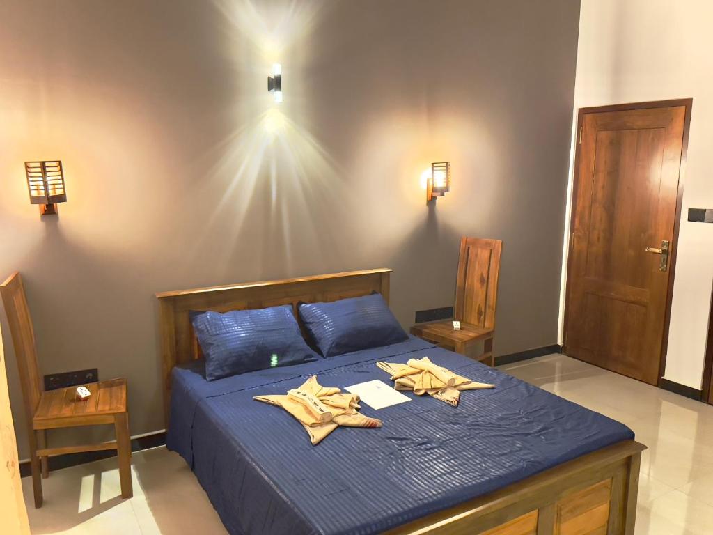 a bedroom with a blue bed with two towels on it at Domus Taprobana in Dankotuwa