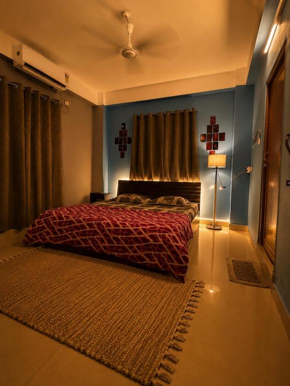 a bedroom with a bed with a red comforter at Elyvia Stays in Guwahati