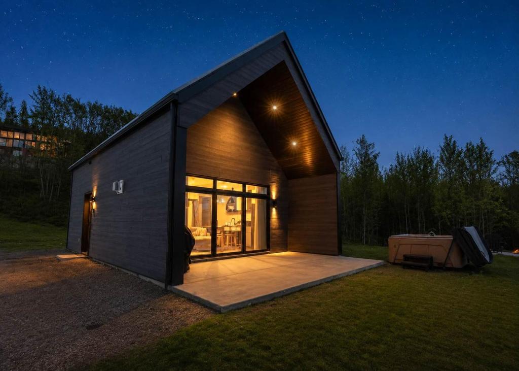 a small house with a large window on a field at Modern Comfort - Spa - Mountain - Chalet ALBA in Saint Come
