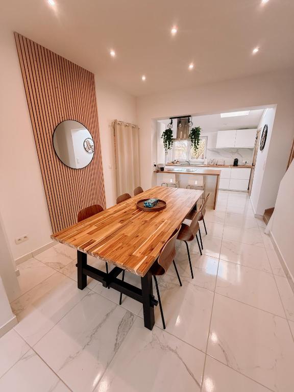 a kitchen and dining room with a wooden table and chairs at AirportHouse in Charleroi