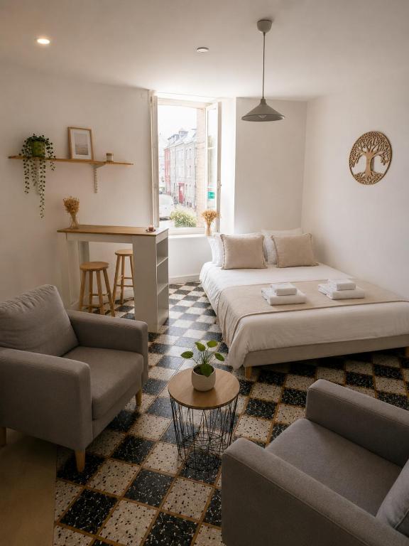 a living room with a bed and a couch and a table at Studio Notre Dame in Château-Chinon