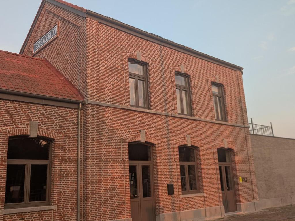 a red brick building with doors and windows at De oude statie in Tessenderlo