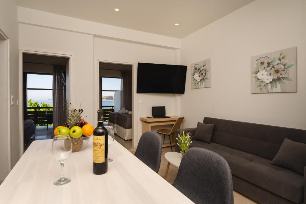 a living room with a table with a bottle of wine at Nimaria Suites in Gialova