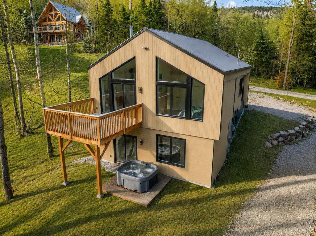 an overhead view of a small house with a deck at Spa & Foosball - Le WKD in Saint-Philémon