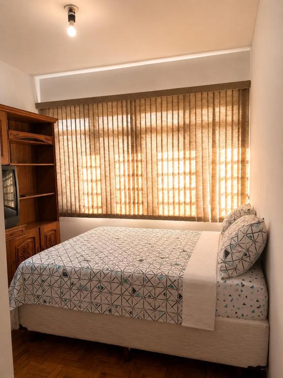 a bedroom with a bed in front of a window at Hospedagem da Renata in Salto