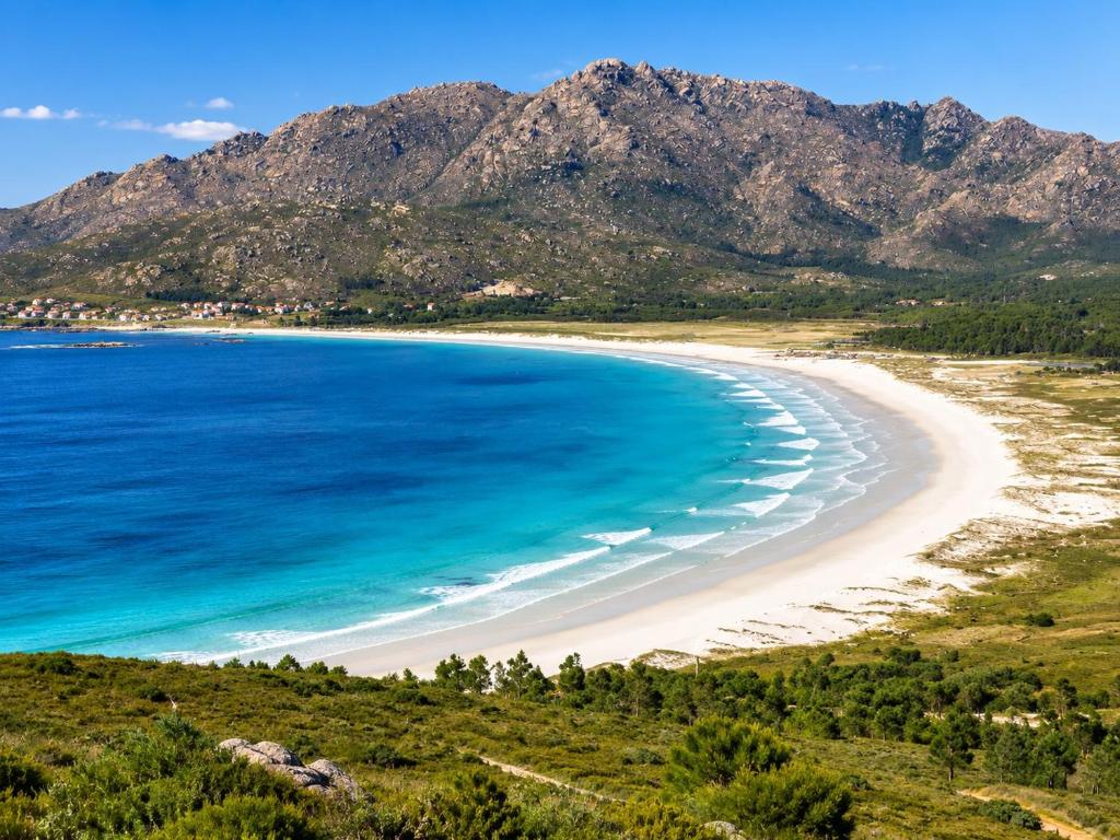 a view of a beach with mountains in the background at Apartamento Mar de Carnota in San Mamede de Carnota