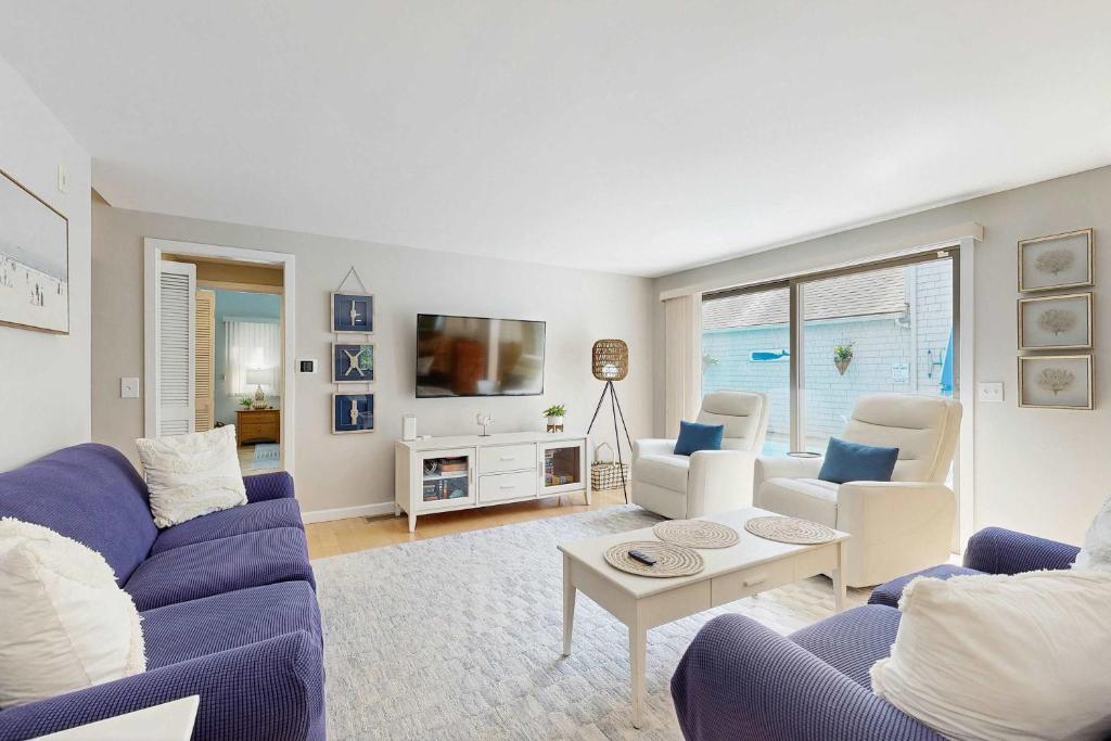 a living room with blue couches and a tv at New Seabury Escape in Mashpee