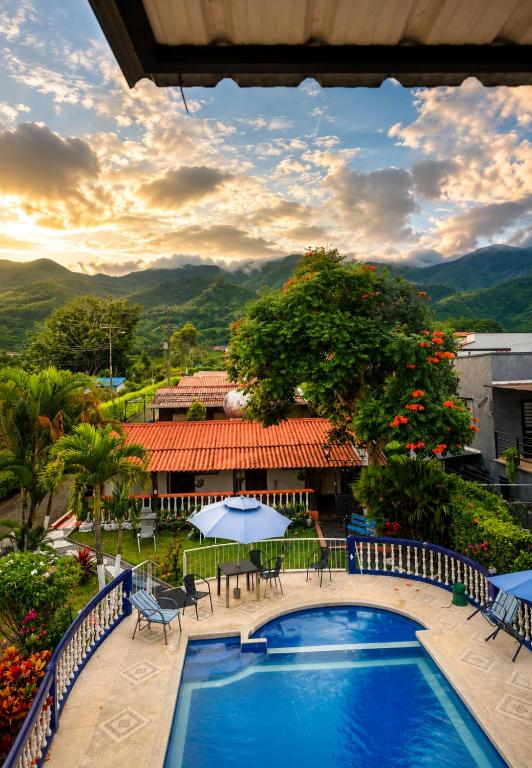 a view of a resort with a pool and tables and chairs at Complejo Campestre Salome Cabañas & Hotel in Calima