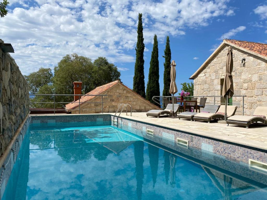 a swimming pool with blue water in front of a house at Villa Zeleni raj in Omiš