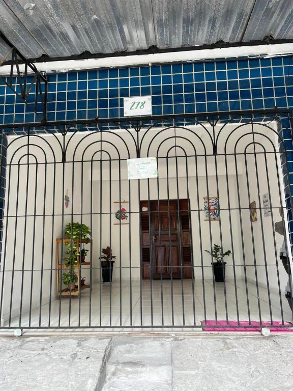 a gate in front of a building with a door at JARDIM TROPICAL - QUARTO 03 ar-condicionado in Bayeux