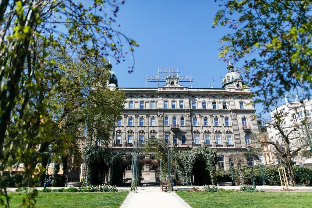 a large building in front of a park at Hotel Continental in Pilsen