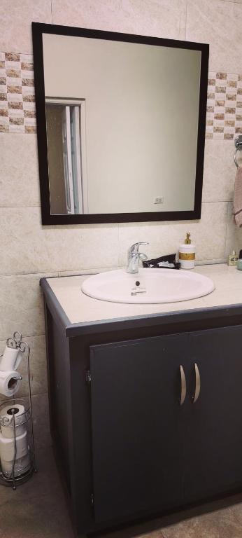 a bathroom with a sink and a mirror at Spice N Honey in Port-of-Spain