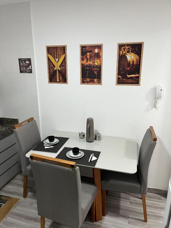 a dining room table with chairs and posters on the wall at Apartamento Central in Montes Claros