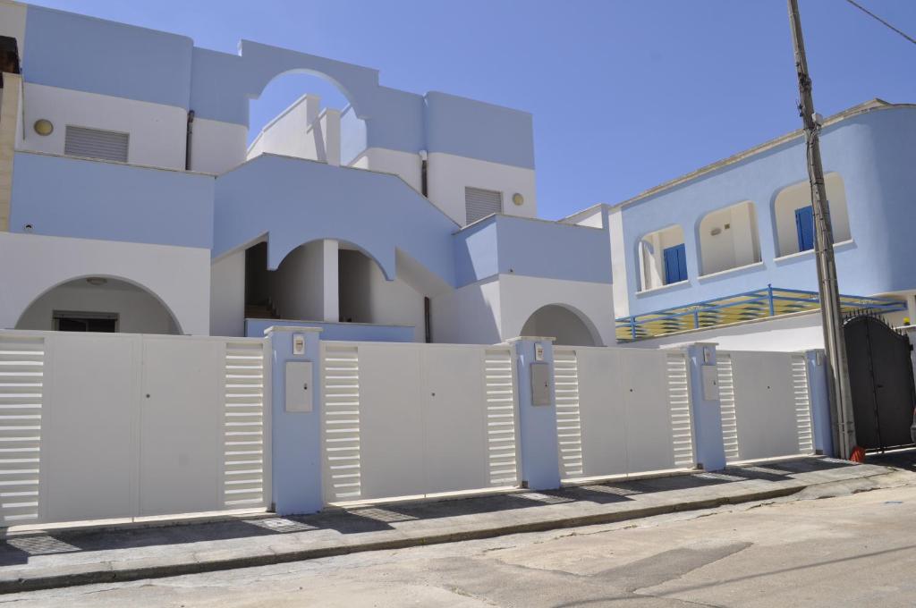 una fila di cancelli di fronte a un edificio di Residence Magic Sea Lido Marini a Lido Marini