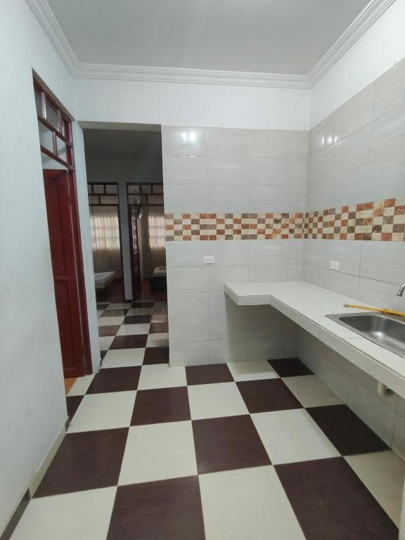a large kitchen with a checkered floor at Villa Tania in Melgar