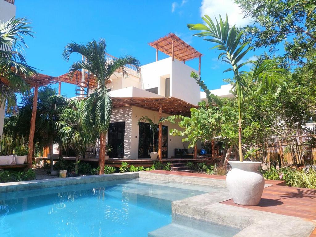a villa with a swimming pool in front of a house at Design Luxury Villa in Holbox Island
