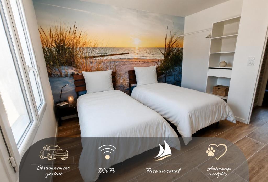 two beds in a room with a view of the ocean at Le temps de la pause 1 in Cepoy