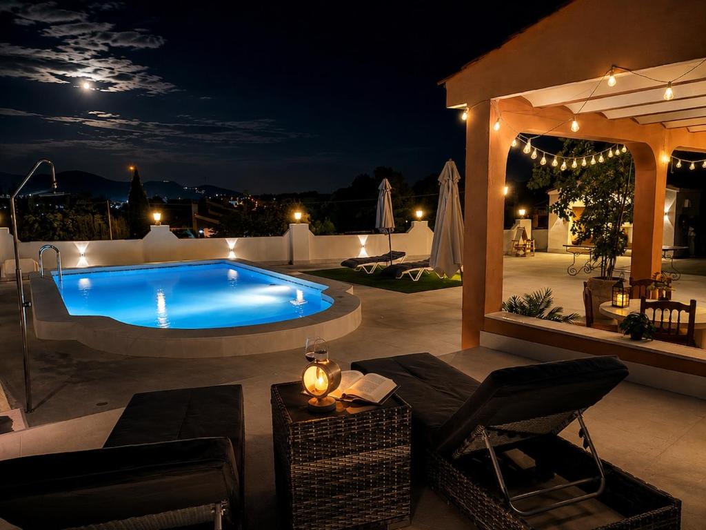 a swimming pool on a patio at night at El Refugio de Leyla in Masía de Correntilla