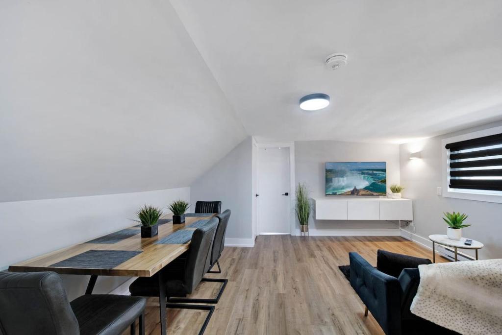 a dining room with a table and chairs at Modern 1 Bdrm with Laundry, BBQ, Deck in Welland