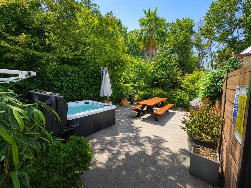a backyard with a hot tub and a picnic table at Porters Cottage Garden in Albury