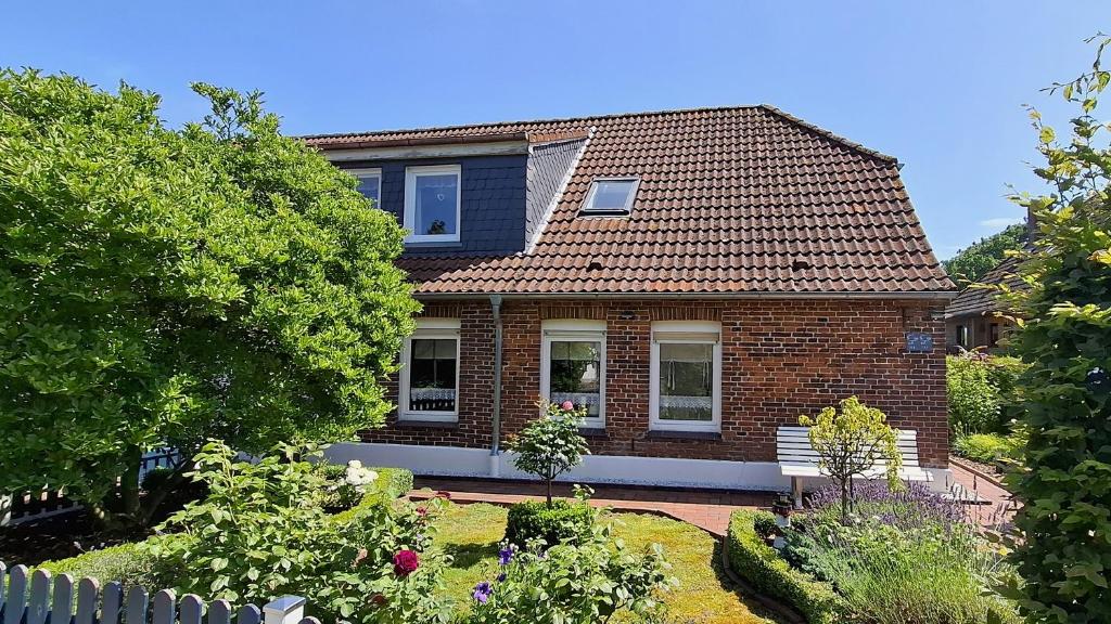 a brick house with a garden in front of it at Ferienwohnung Alte Schmiede in Wangerland