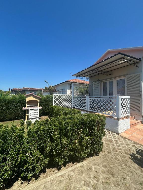 a house with a white porch and bushes at Loft Pietrasanta in Pietrasanta