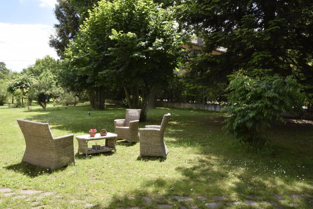 eine Gruppe Stühle und ein Tisch im Gras in der Unterkunft Capannone111 in Castiglione di Ravenna