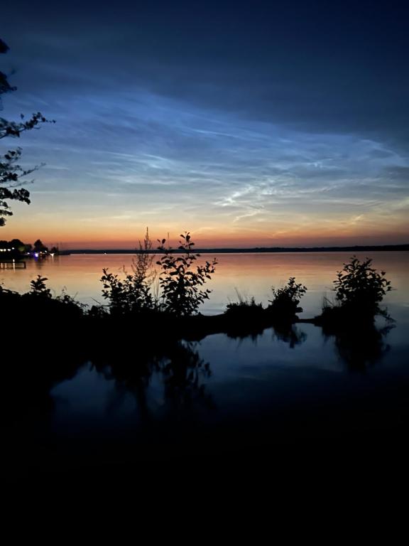 a sunset over a large body of water at Pokoje i apartamenty MatDar in Mikołajki