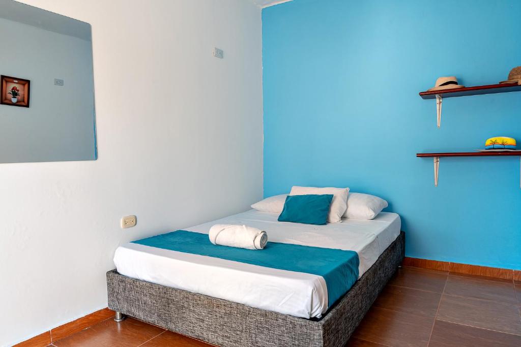 a bedroom with a bed with a blue wall at Casa Blanca in Santa Marta