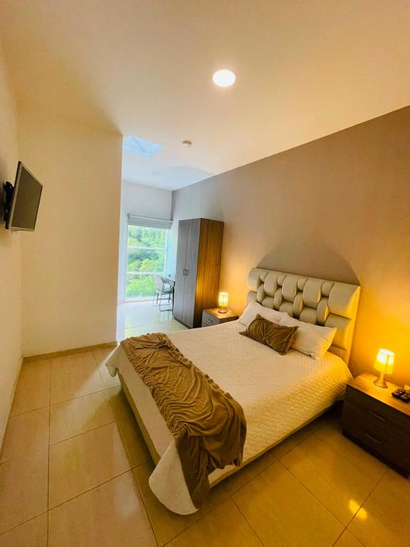 a bedroom with a large bed and a window at Hotel Mall Roma in Pereira