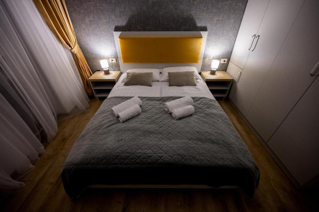 a bedroom with a large bed with two pillows at Central Rent Apartments in Suceava