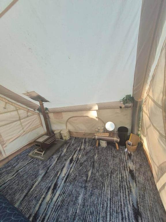 a tent room with a wooden floor and a table at Tiny Timber Tent in West Danby
